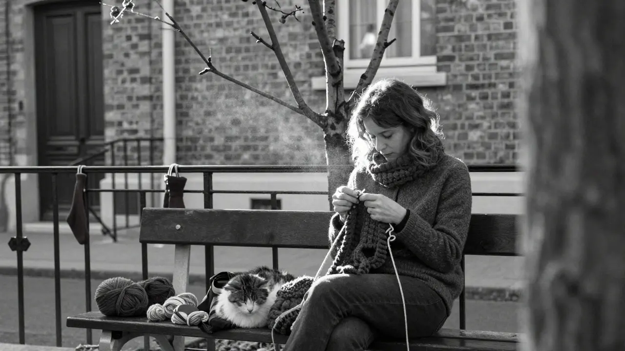 A woman knitting on a bench with her cat asleep on her lap, a red sock hanging nearby, bare tree behind.